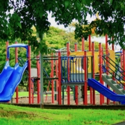 A colourful playground, inviting kids to play there. Combination playground structure for small children including slides, climbers, playhouse